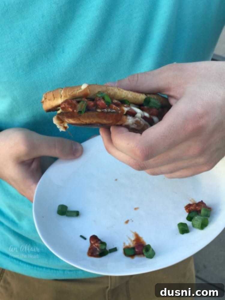 Fiery Chili Cheese Dog Melt 11 Person holding a Spicy Grilled Cheese Chili Dog