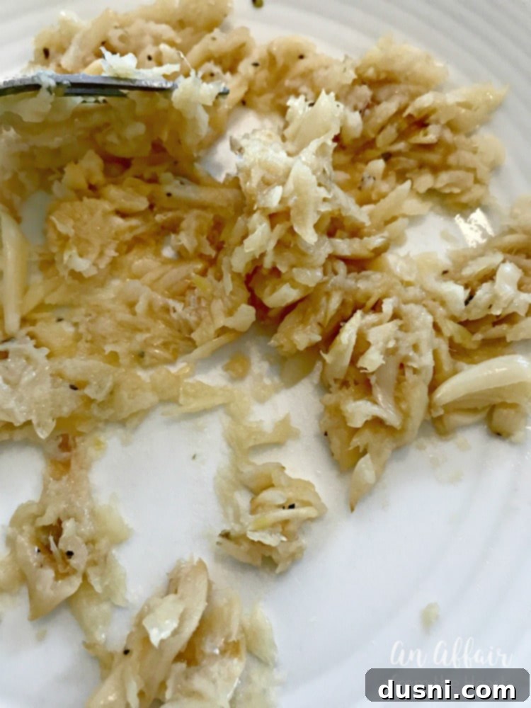 Golden Roasted Garlic Butter 5 Creamy, golden mashed roasted garlic in a bowl, the foundation of an incredible butter.