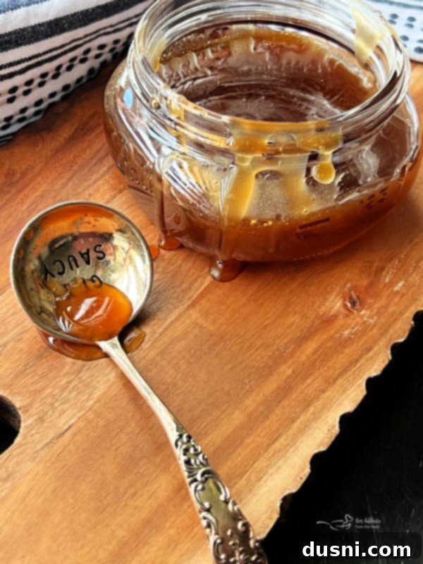 Bourbon Honey Sauce 2 Delicious Honey Bourbon Sauce in a white bowl with a spoon