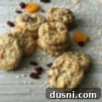 Cranberry Apricot Oatmeal Cookies stacked on a wood table, ready to be enjoyed.