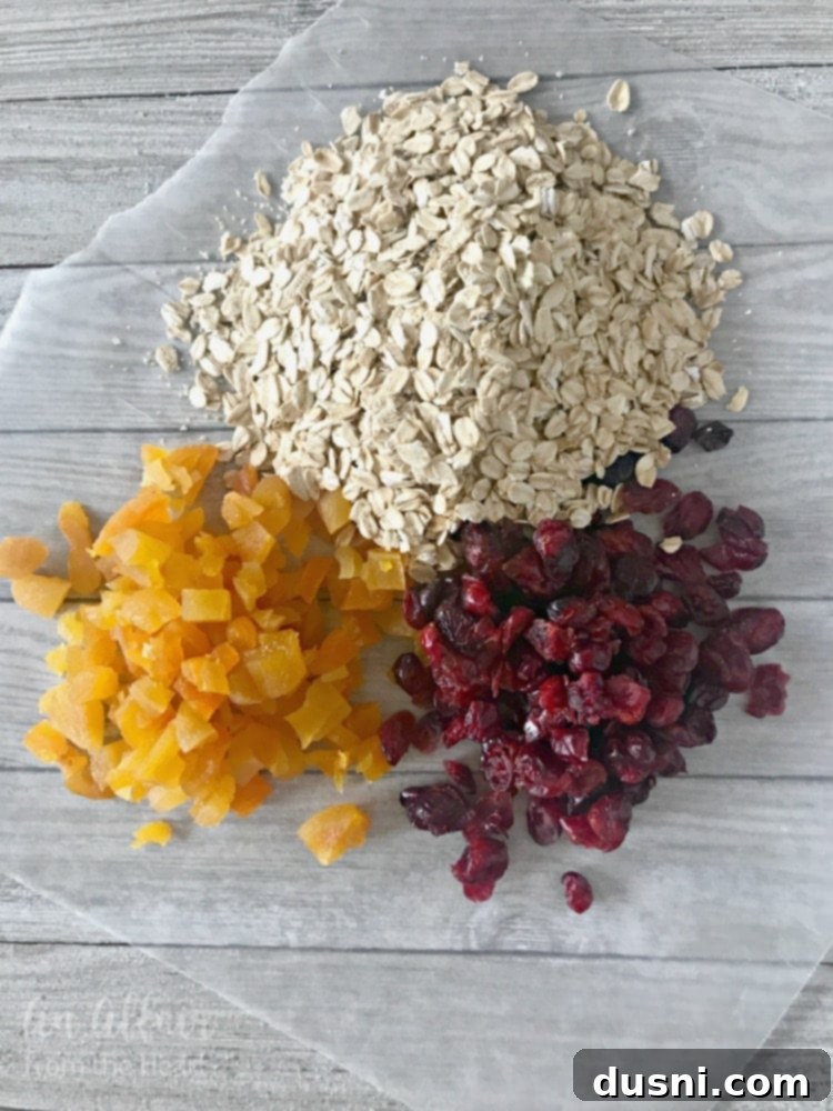 Ingredients for Cranberry Apricot Oatmeal Cookies laid out, including oats, dried cranberries, and chopped apricots.