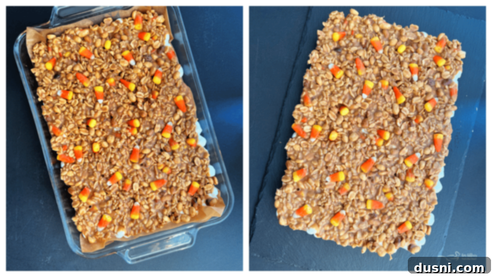 Spreading peanut butter mixture over marshmallows for Candy Corn Salted Nut Roll Bars