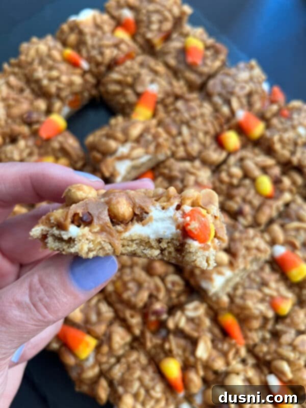 Close up of Candy Corn Salted Nut Roll Bars with a gooey marshmallow and peanut butter topping
