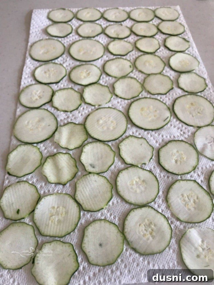 Zucchini slices being dried with paper towels