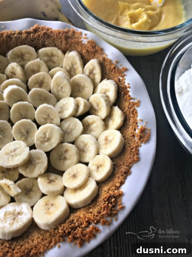 Graham cracker crust being pressed into a pie pan