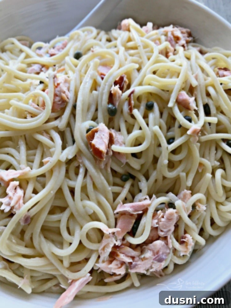 Savory Smoked Salmon Pasta 5 Smoked Salmon Pasta - A close-up shot of the smoked salmon pasta, showing the delicate sauce and capers mixed in with the salmon flakes.