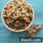 Overhead view of homemade Fresh Apple Cinnamon Granola in a bowl, ready to serve.