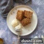 Spiced Applesauce Coffee Cake 13 Three pieces of Applesauce coffee cake and ice cream on a white plate.