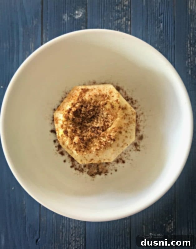 Homemade Dairy Queen Apple Pie Blizzard 8 Apple seasoned with cinnamon and nutmeg in a bowl, covered tightly with plastic wrap for microwave cooking.