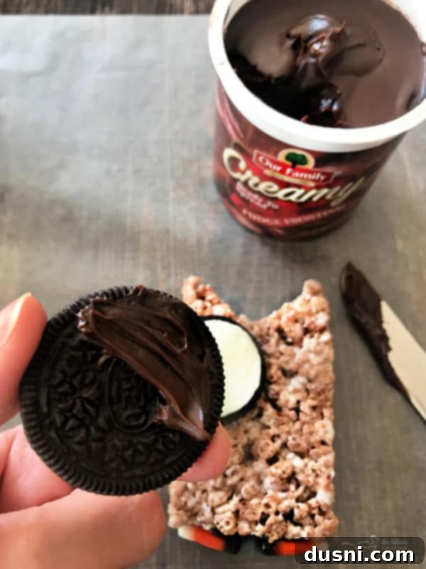 Applying candy decorations to Cocoa Krispy Owls with frosting