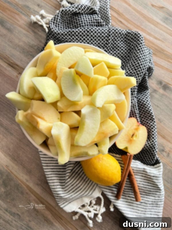 Peeled and cored apples with cinnamon sticks, ready for homemade apple sauce