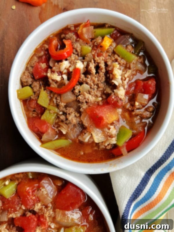 Two bowls of hearty Stuffed Pepper Soup with rice and ground beef, garnished with fresh parsley.