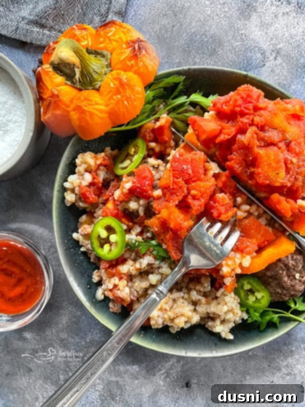 A single stuffed bell pepper, expertly prepared and ready to eat, served on a white plate.