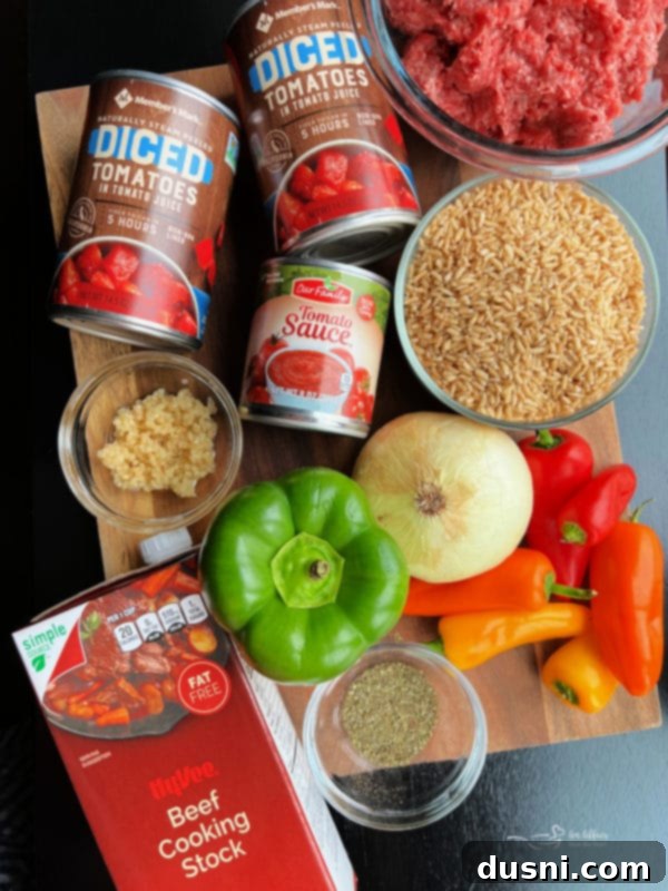 A vibrant array of fresh ingredients for Stuffed Pepper Soup, including ground beef, bell peppers, tomatoes, and seasonings.