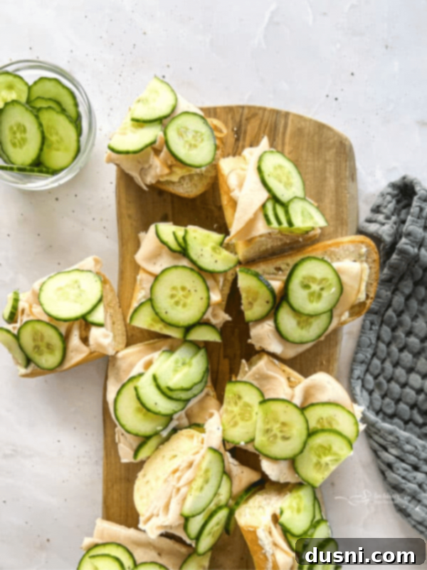 Turkey Ranch Baguettes on a wood board with fresh cucumbers.