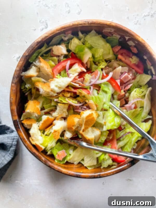 Little King Salad and tongs in a large wooden bowl