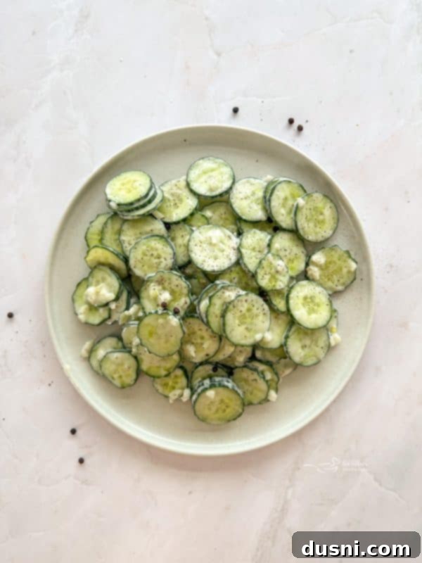 A bowl of creamy Cucumber Ranch Salad with a serving spoon.