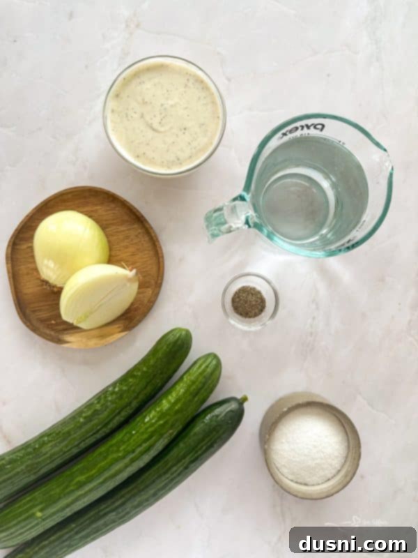 Ingredients for Cucumber Ranch Salad laid out on a table: sliced cucumbers, chopped onion, and ranch dressing.