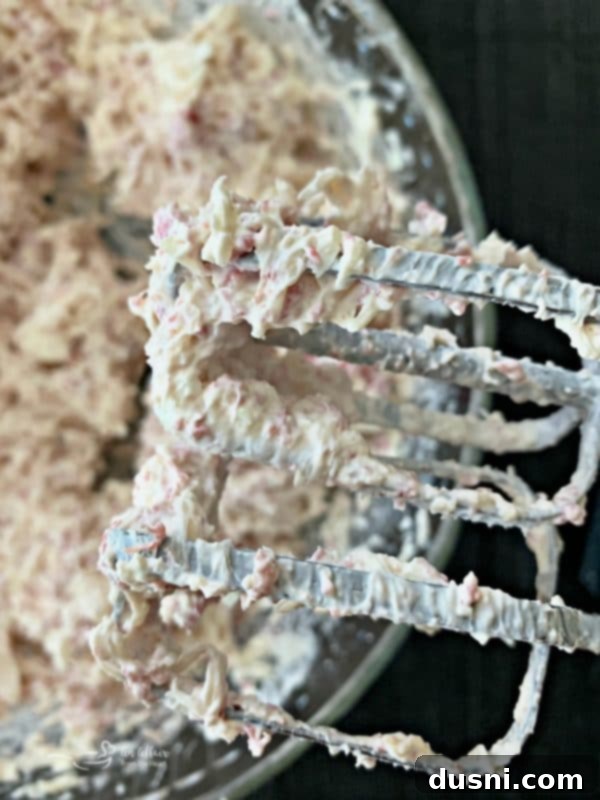 Child licking a mixer beater with Reuben Dip