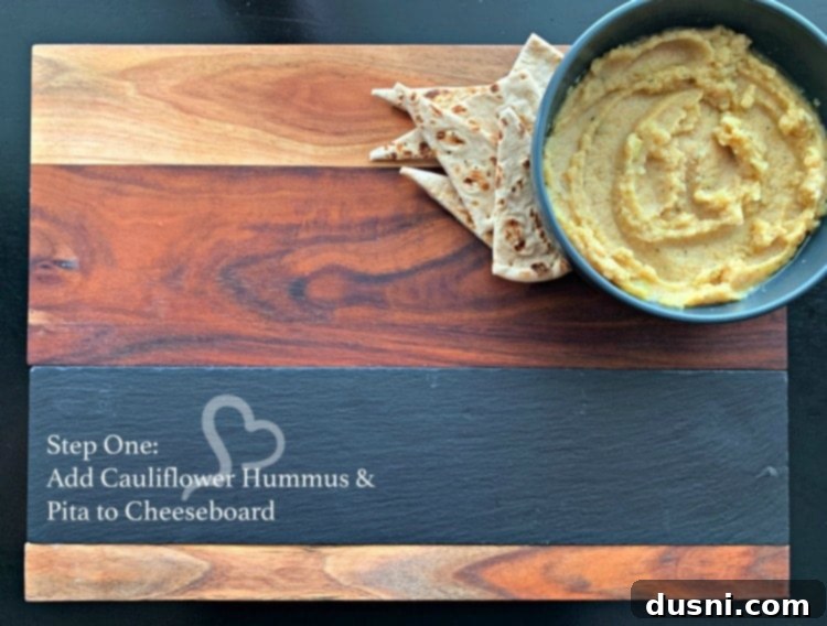 Sun-Kissed Mezze Platter with Creamy Cauliflower Hummus 12 Step one: Placing Cauliflower Hummus and pita on a Mediterranean cheeseboard