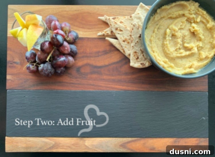 Sun-Kissed Mezze Platter with Creamy Cauliflower Hummus 13 Step two: Adding fruits like pears and grapes to a Mediterranean cheeseboard