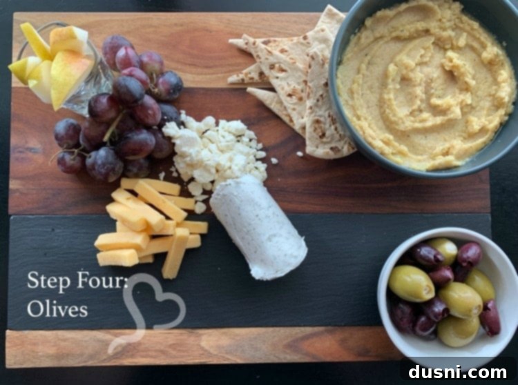 Sun-Kissed Mezze Platter with Creamy Cauliflower Hummus 15 Step four: Adding Kalamata and feta-stuffed Spanish Queen olives to the cheeseboard