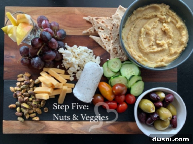 Sun-Kissed Mezze Platter with Creamy Cauliflower Hummus 16 Step five: Adding pistachios, tomatoes, and cucumbers to the Mediterranean cheeseboard