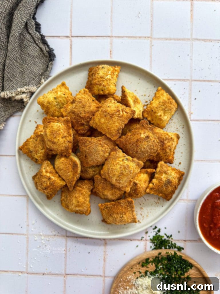 Air fryer toasted ravioli stacked on a plate.