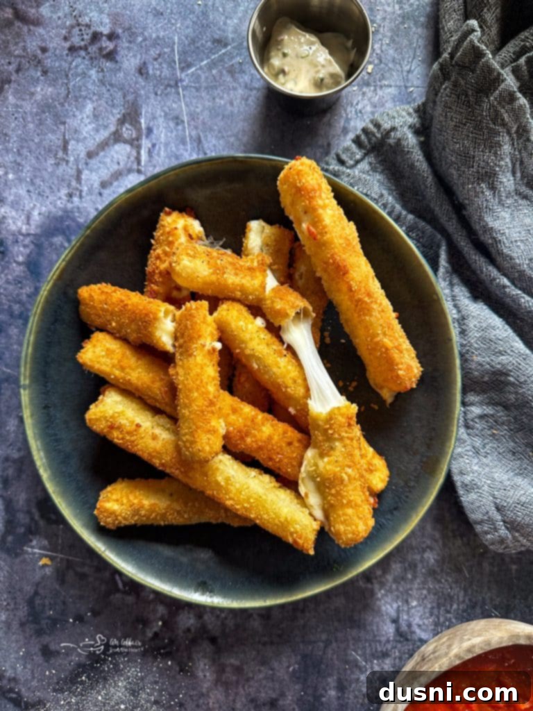 Mozzarella sticks on a green plate, another air fryer appetizer.