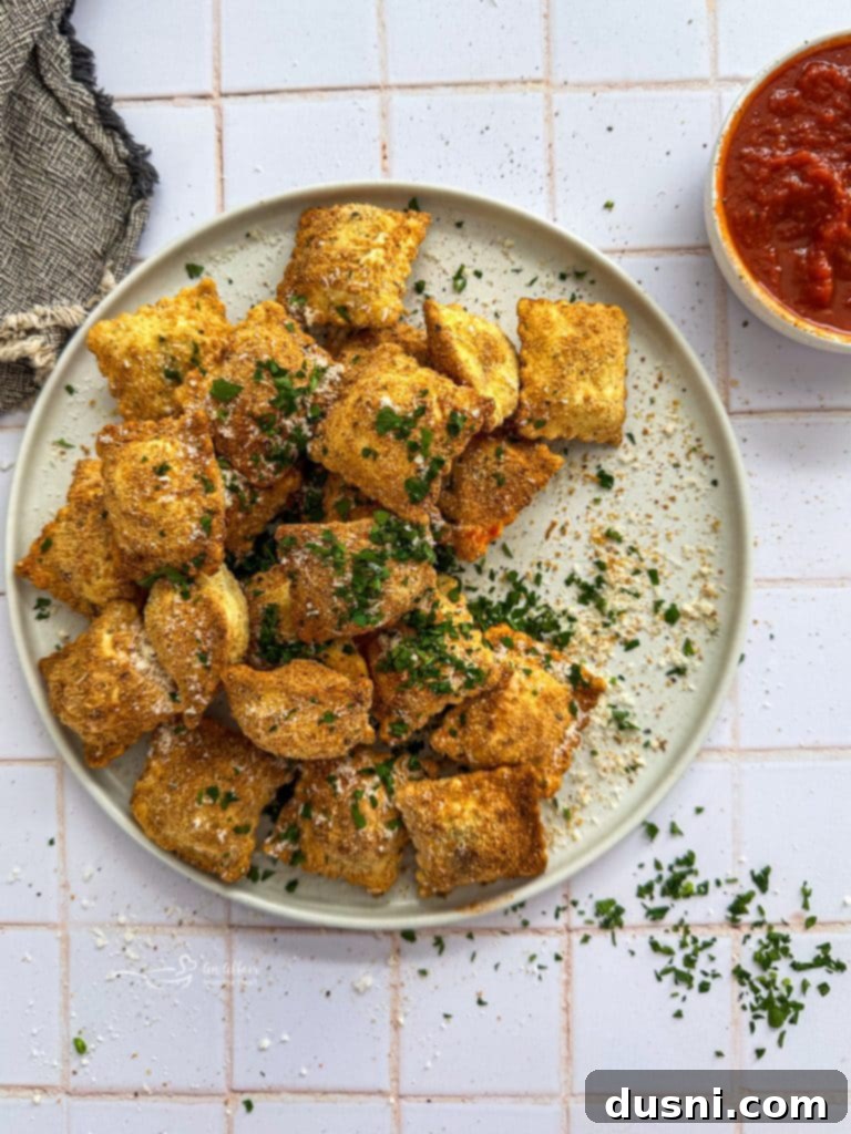 Air fried ravioli in the air fryer basket.