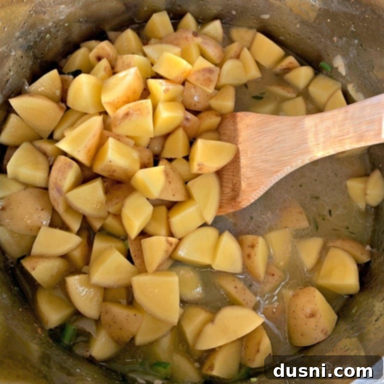 Potatoes added to the Instant Pot with sautéed bacon and vegetables, before adding liquid