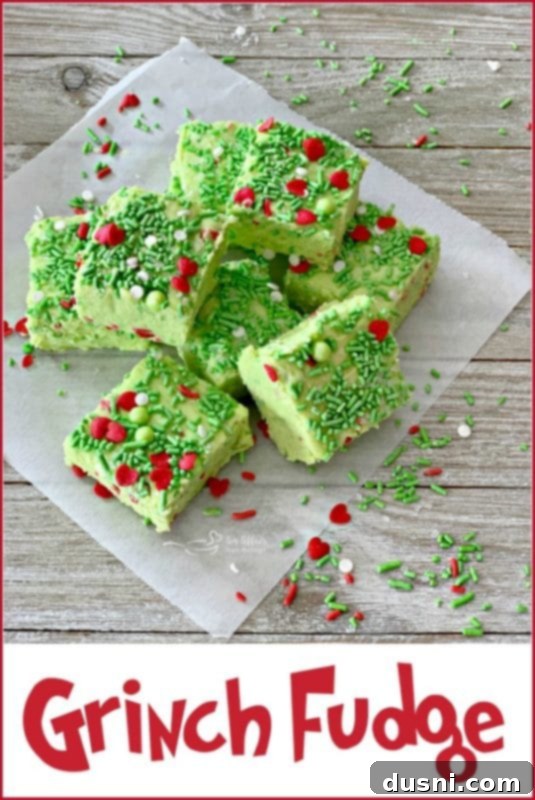 Close-up of fluffy Grinch Fudge cubes, showcasing the vibrant green color and festive sprinkles.