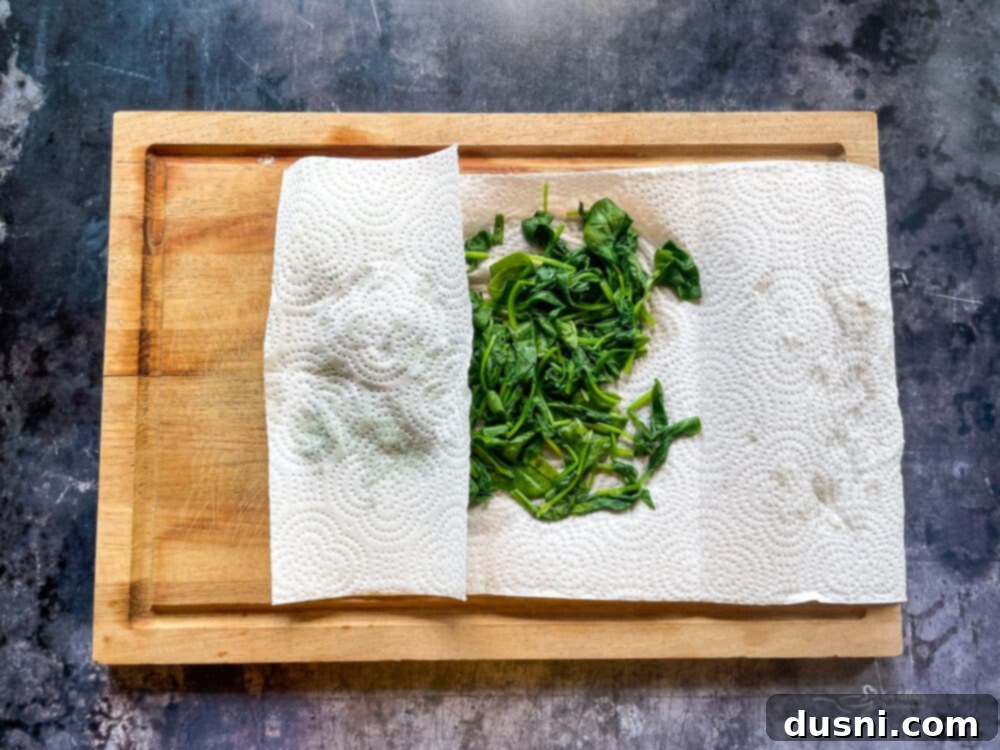 Remove the spinach and place it on a paper towel, pat all of the liquid out of the spinach.