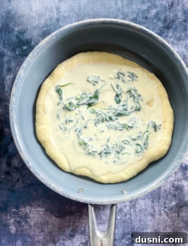 Spread spinach alfredo mixture over your crust, and top with artichokes and shredded mozzarella cheese.