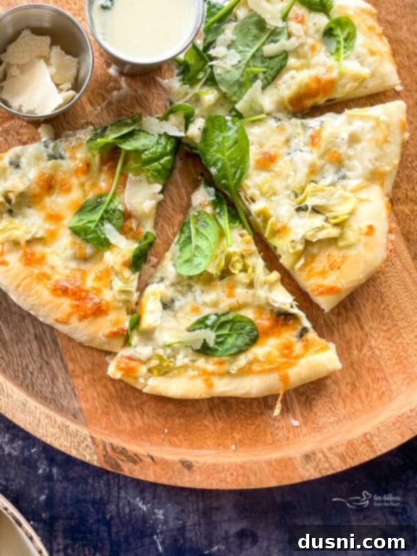 cutting and serving spinach and alfredo pizza