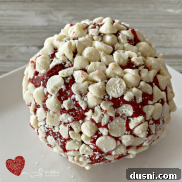 Crimson Velvet Cheese Bomb 6 Red Velvet Cheese Ball fully coated in white chocolate chips, ready for serving.