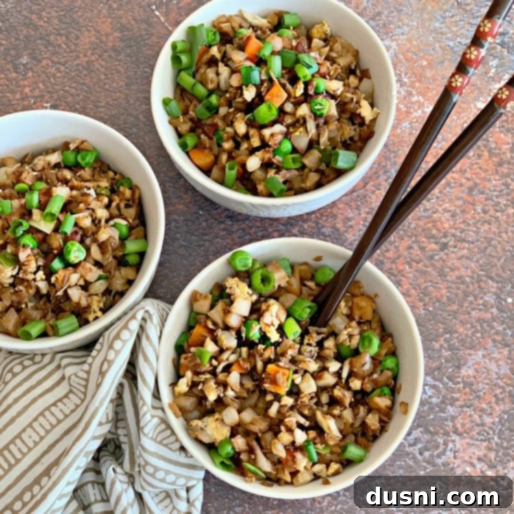 Cauli Power Stir-fry 2 Cauliflower Fried Rice served in a white bowl with chopsticks