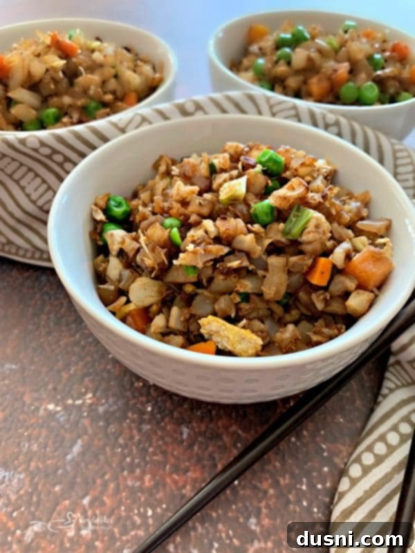 Cauli Power Stir-fry 4 Close-up of Cauliflower Fried Rice in a white bowl with a fork