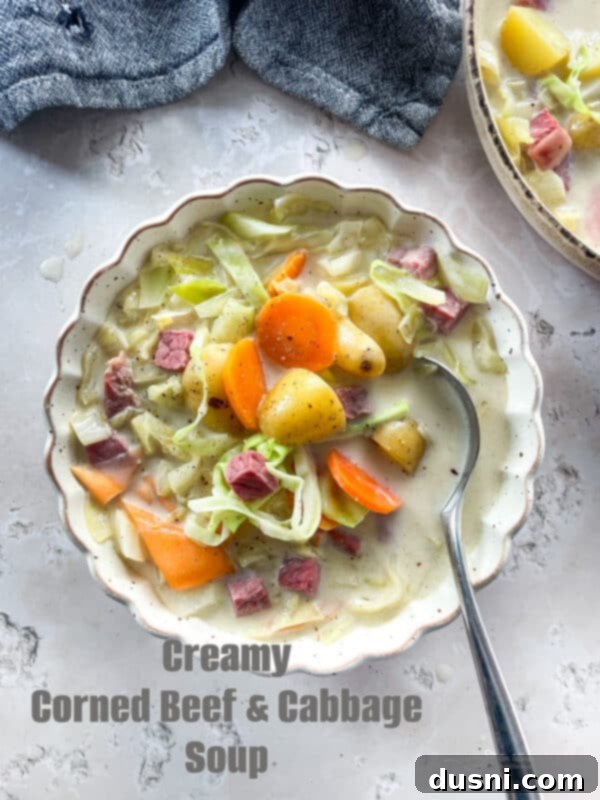 Corned Beef and Cabbage Comfort Soup 15 Creamy Corned Beef & Cabbage Soup in a white scallopped bowl with spoon
