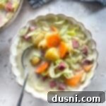 Corned Beef and Cabbage Comfort Soup 17 Creamy Corned Beef & Cabbage Soup in a white scallopped bowl with spoon