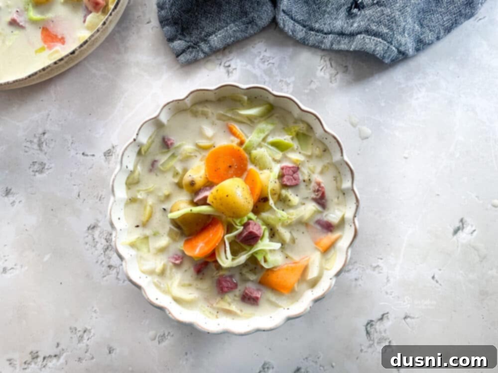 Corned Beef and Cabbage Comfort Soup 7 Creamy Corned Beef & Cabbage Soup in a white scalloped bowl