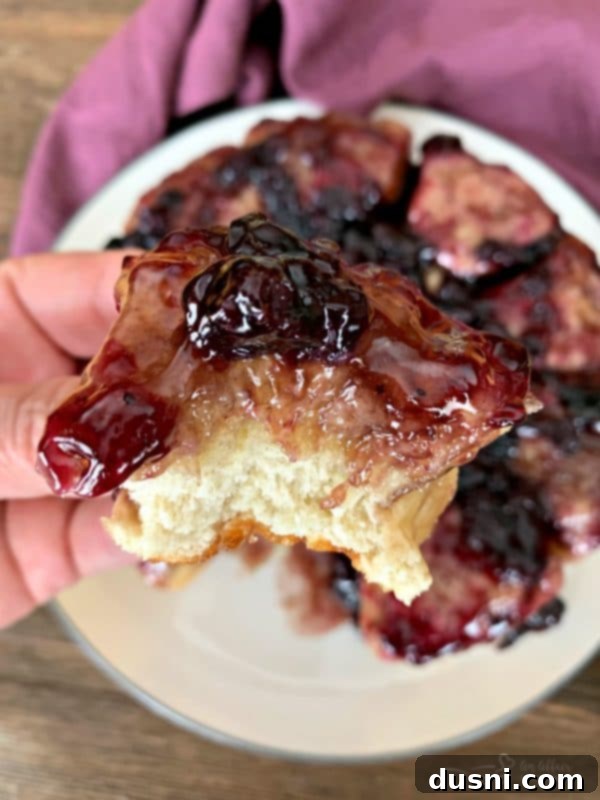 Caramelized Blueberry Upside-Down Rolls 11 Blueberry Sweet Rolls: A stack of three gooey upside-down blueberry sweet rolls on a white plate, showcasing their inviting texture.