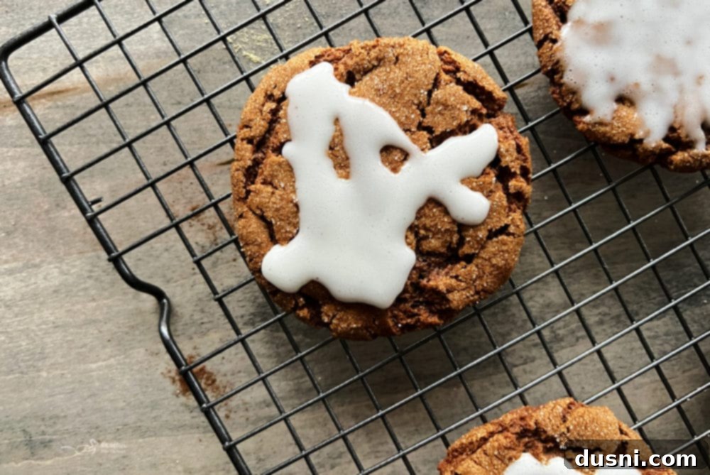 one iced molasses cookie on wire rack