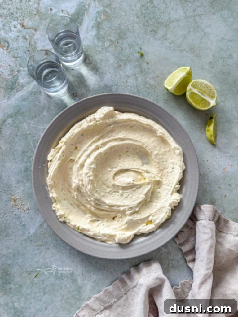 Ultimate Margarita Pretzel Dip 7 Individual ingredients for Margarita Dip laid out on a table, including cream cheese, cool whip, butter, tequila, and lime.