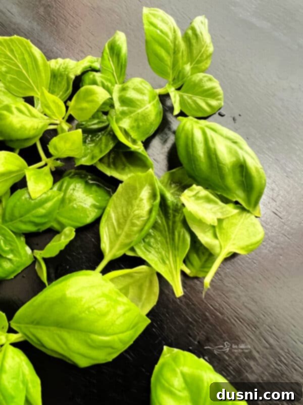 A close-up shot of the fresh ingredients of Caprese salad - red tomatoes, white mozzarella, and green basil - on a wooden board.