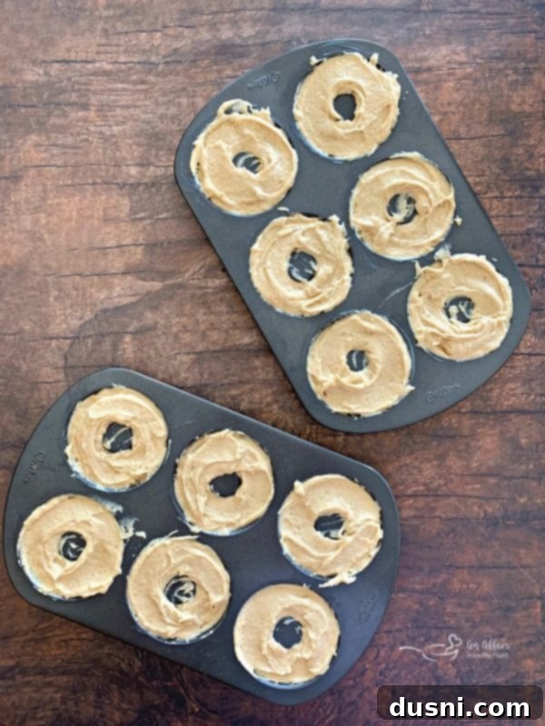 Filling donut pans with batter for Baked Powdered Sugar Donuts