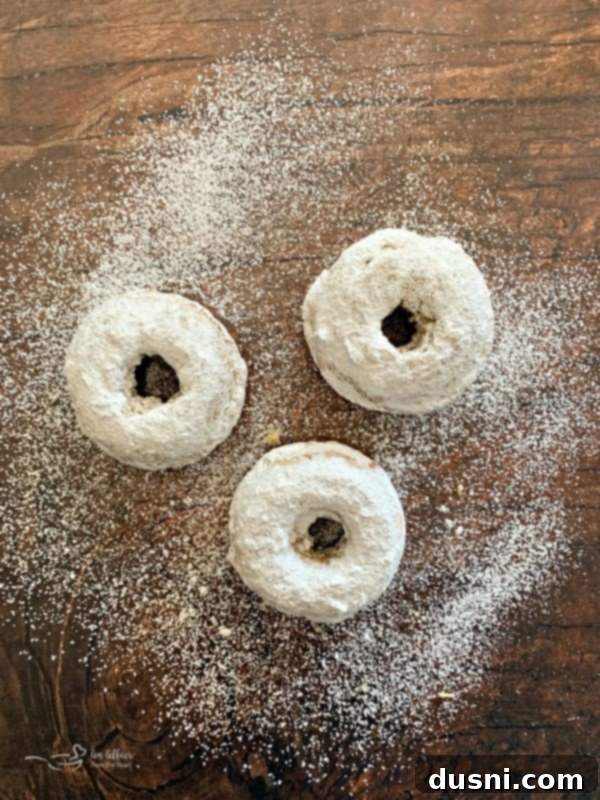 Dusting Baked Powdered Sugar Donuts with powdered sugar