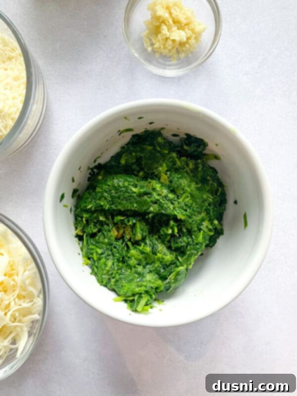 The creamy, cheesy spinach artichoke dip served hot in a small baking dish, garnished with fresh herbs.