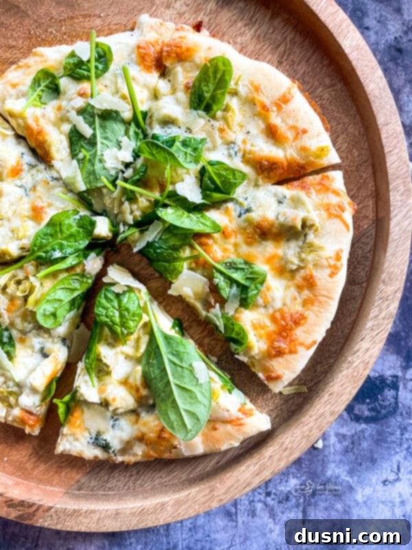 Spinach & Artichoke Alfredo Pizza combines the creaminess of Alfredo sauce and Spinach Artichoke Dip into one EPIC Pizza!