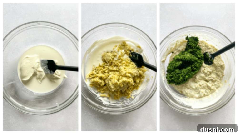 A food processor bowl with blended artichoke, garlic, and cheese mixture, showing a creamy but textured consistency.